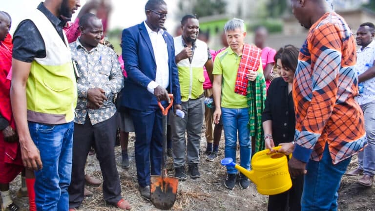 Guests planting a tree at the launch of a community water project